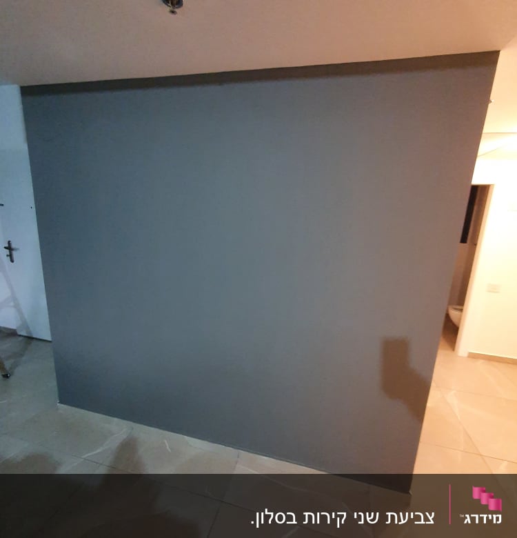 קיר צבוע בצבע אפור כהה על רצפת אריחים